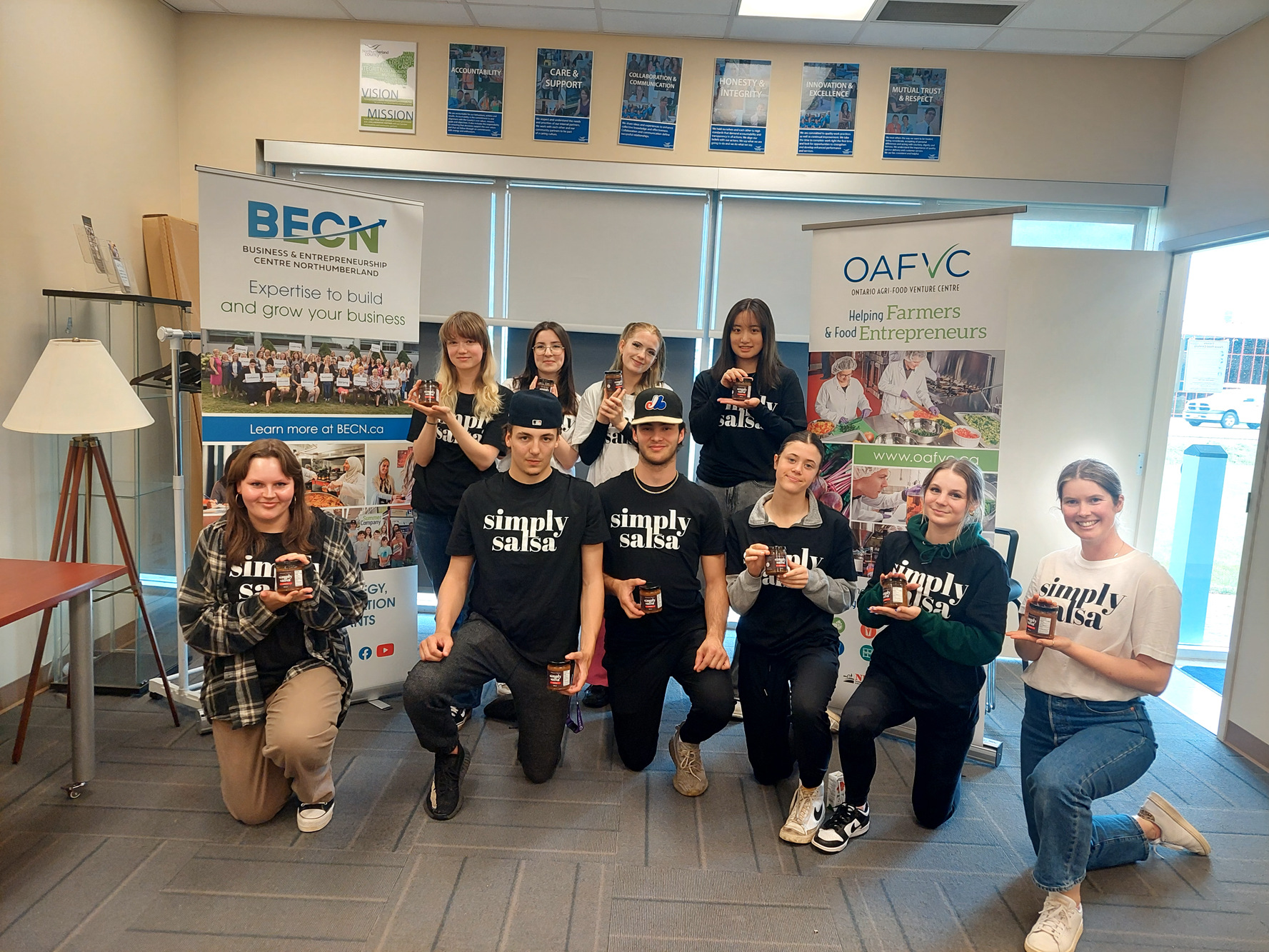 Group of people posing together indoors in front of event banners