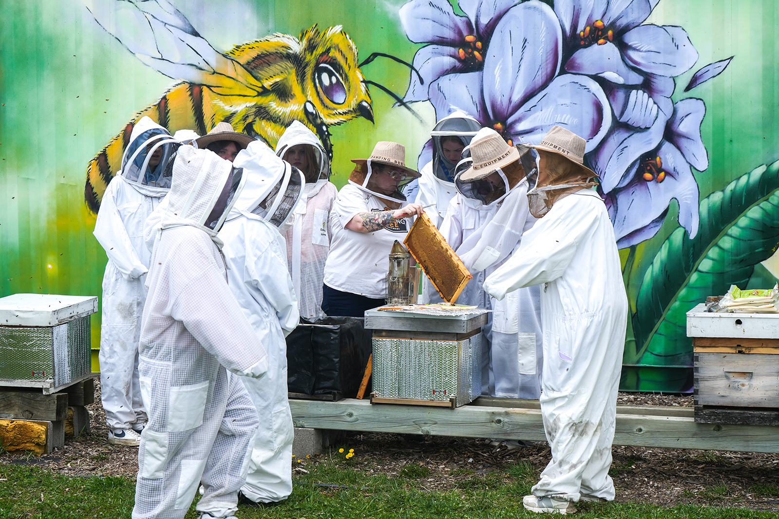Group of students gathered around demonstration at Dancing Bee
