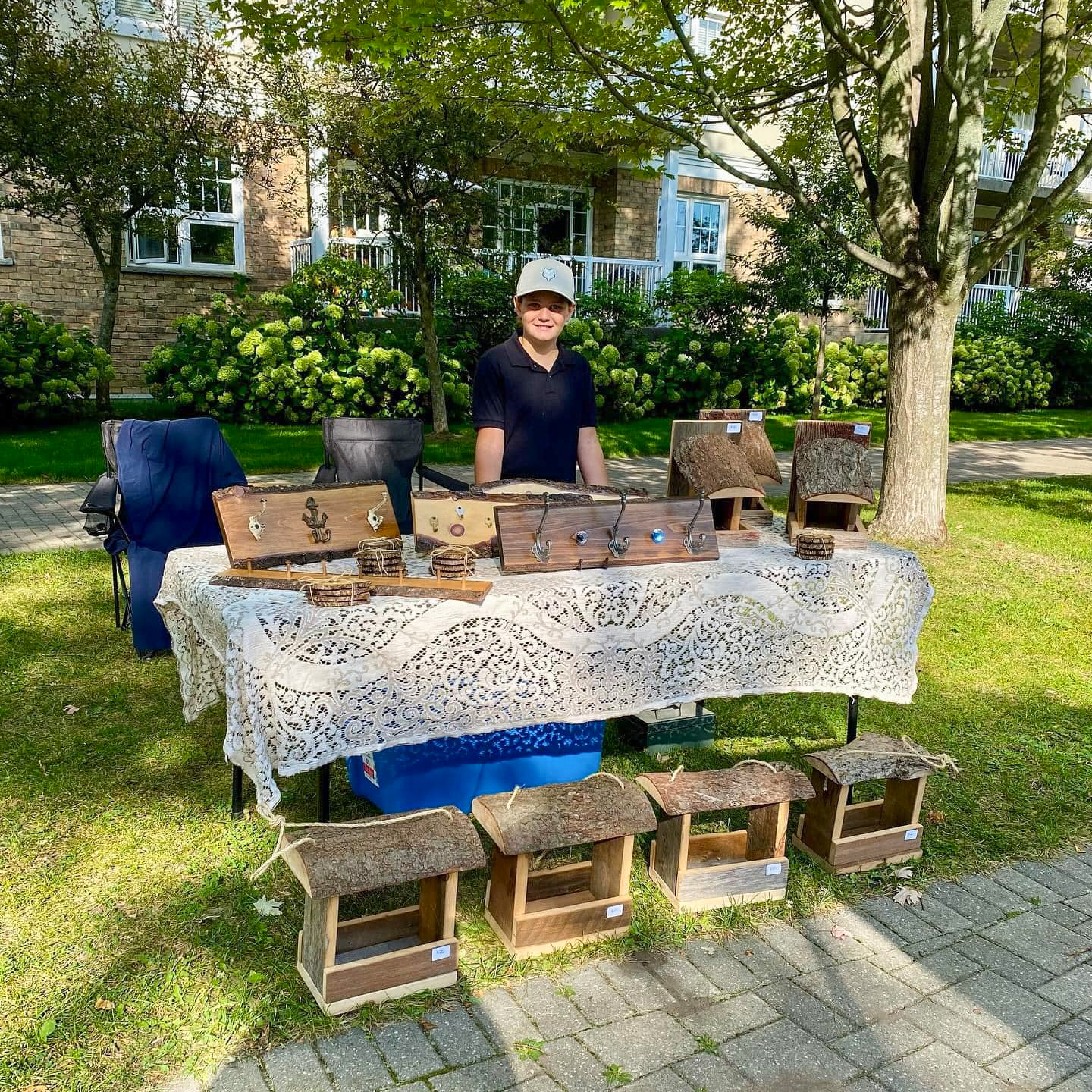 Young boy sells handmade woodworking products at Cobourg Farmer's Market
